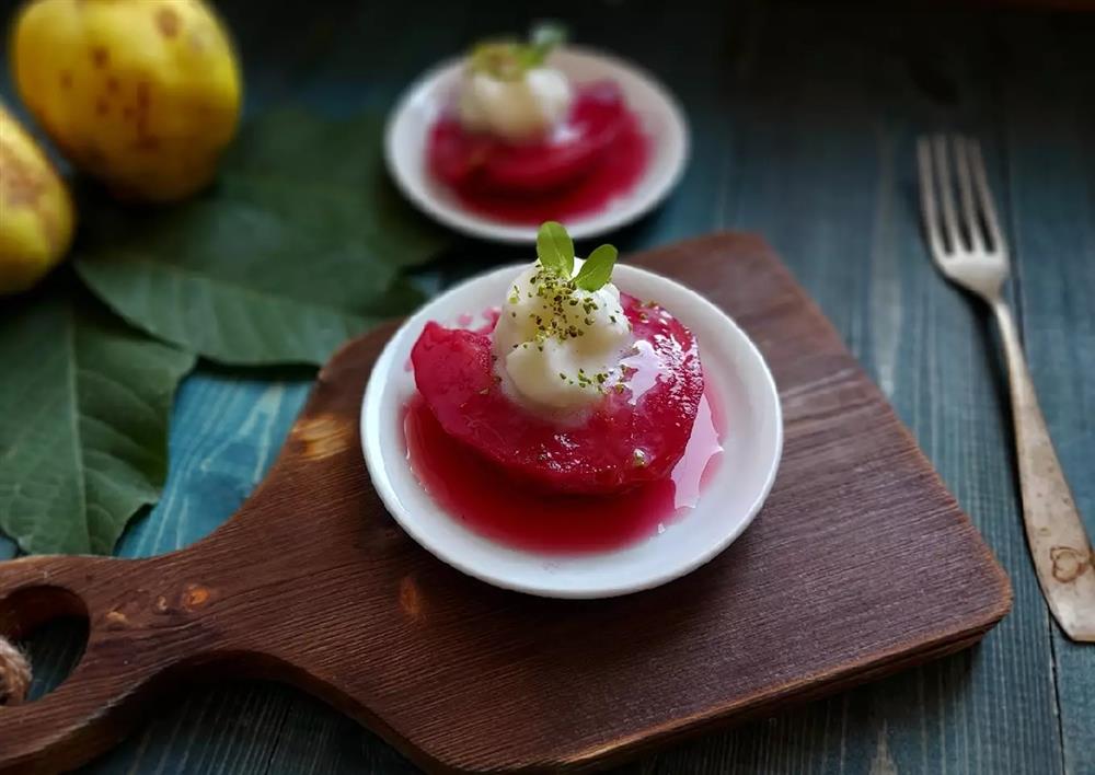 : A bowl of Ayva Tatlisi or Quince dessert a wooden cedar board