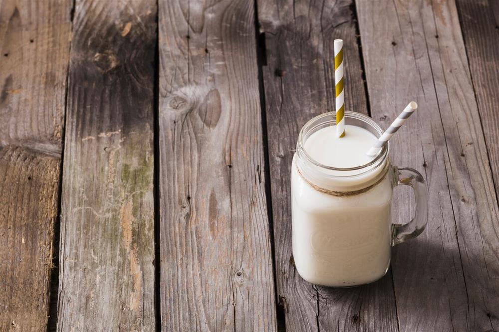 elevated-view-milk-jar-with-two-drinking-straws-wooden