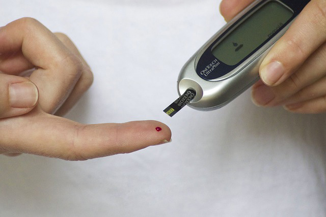 Glucometer in the hand of a person taking her blood sugar test