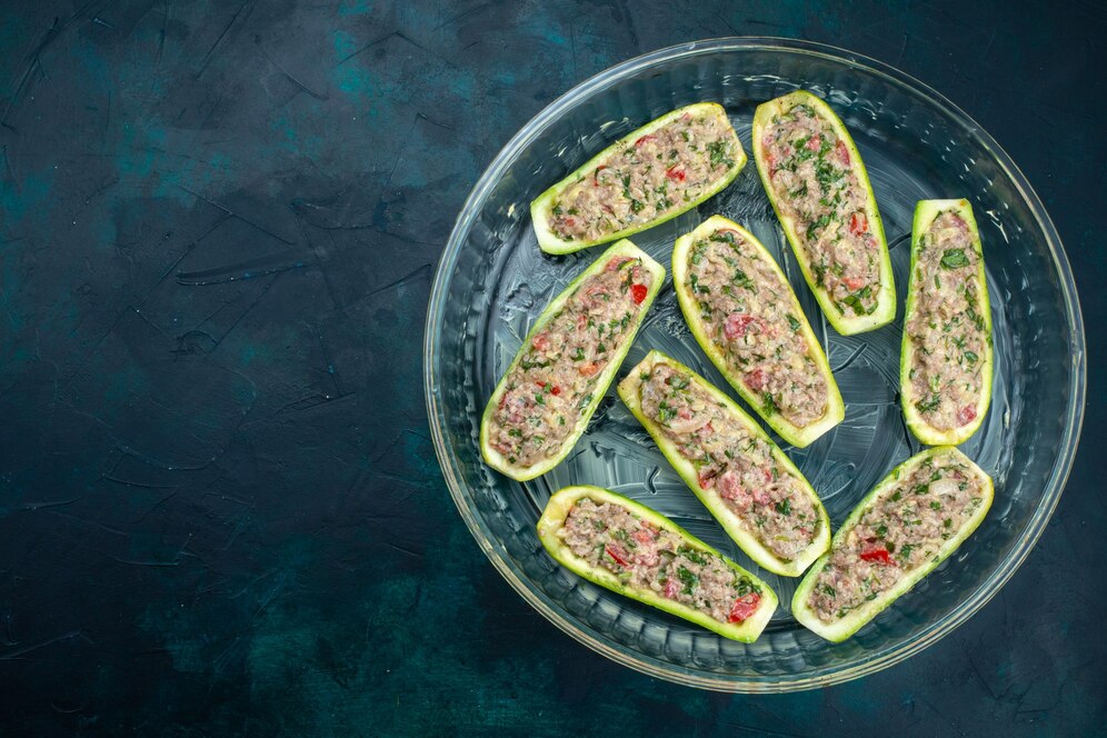 top-view-raw-squashes-with-spicy-minced-meat-inside-glass-plate-dark-blue-surface