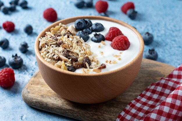 yogurt-with-berries-muesli-breakfast-bowl-blue-background